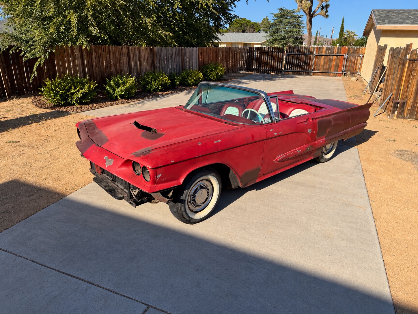 Red 1959 Ford Thunderbird convertible project, photographed in a driveway